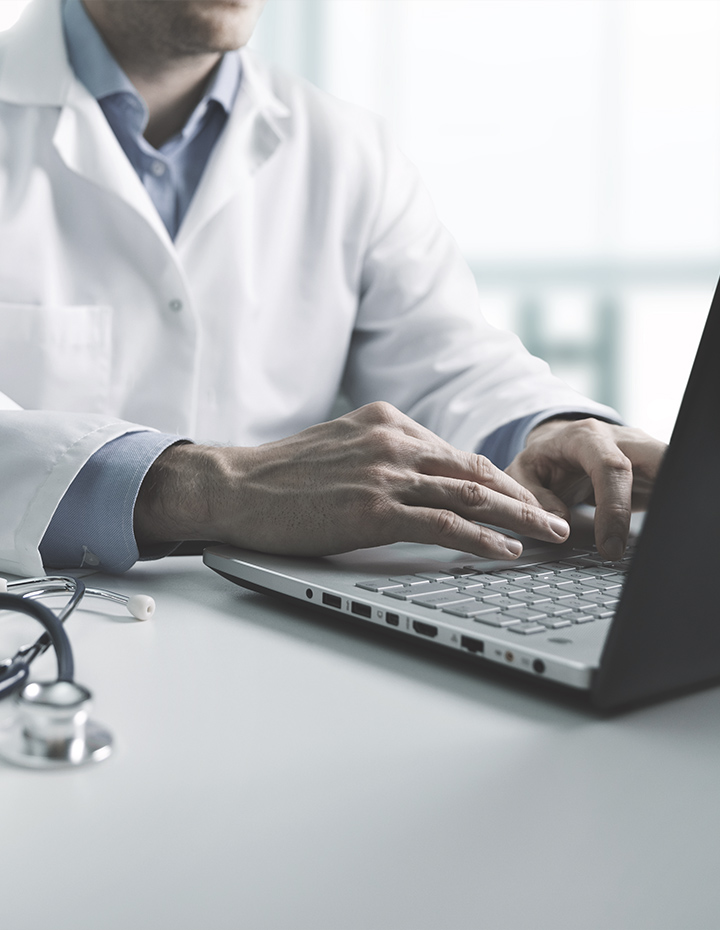 online medical consultation - doctor working on laptop computer in clinic office. copy space